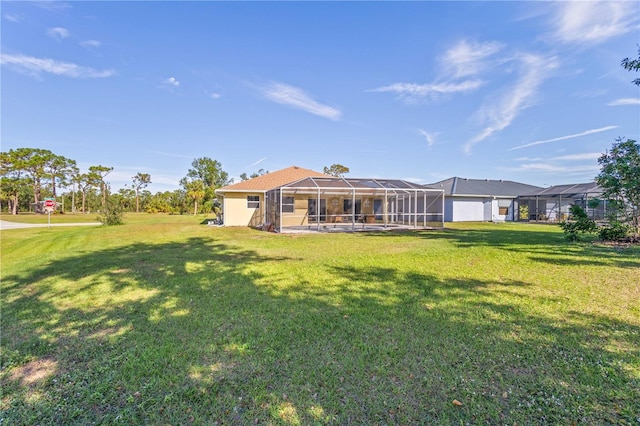 rear view of house featuring glass enclosure and a yard