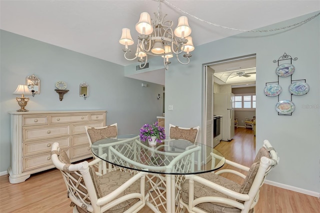 dining room featuring ceiling fan with notable chandelier and light wood-type flooring