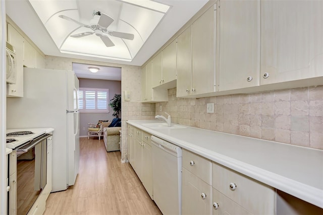 kitchen featuring ceiling fan, sink, tasteful backsplash, light hardwood / wood-style flooring, and white appliances