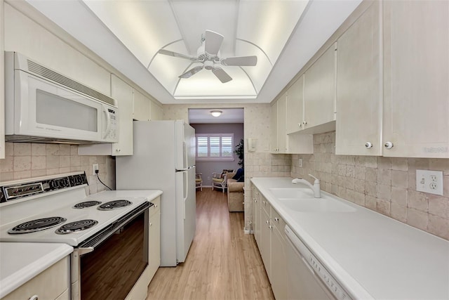 kitchen with ceiling fan, sink, white appliances, decorative backsplash, and light wood-type flooring