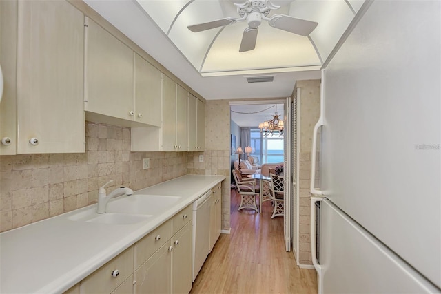 kitchen with ceiling fan with notable chandelier, white appliances, sink, cream cabinets, and light hardwood / wood-style floors