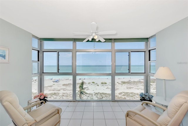 living room with a water view, plenty of natural light, a wall of windows, and ceiling fan