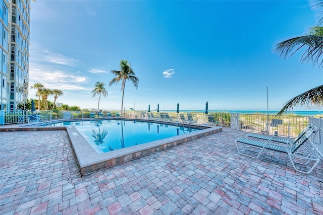 view of pool with a patio area and a water view