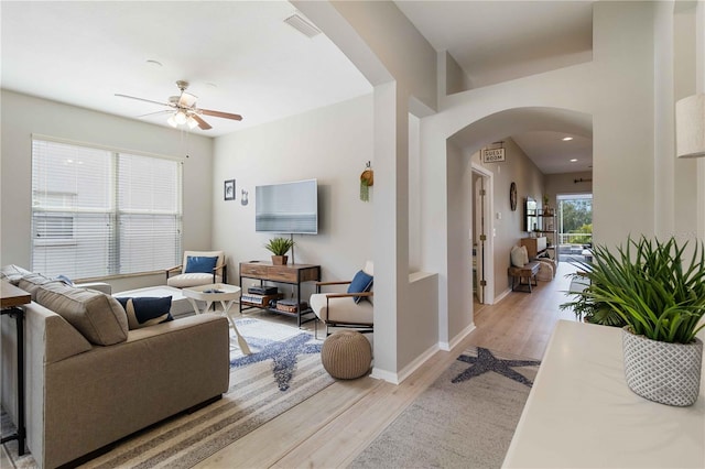 living room with light hardwood / wood-style flooring and ceiling fan