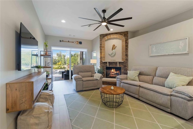 living room with a fireplace, ceiling fan, and light hardwood / wood-style flooring