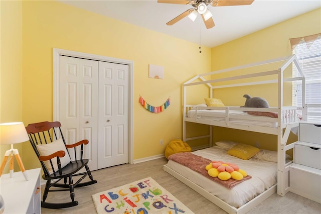 bedroom with light wood-type flooring, a closet, and ceiling fan