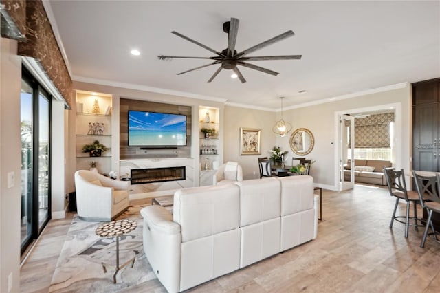 living room with crown molding, light wood-style floors, plenty of natural light, and a premium fireplace