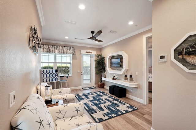 living room featuring ceiling fan, ornamental molding, and hardwood / wood-style flooring