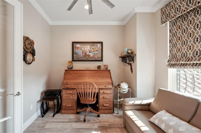 office space with ornamental molding, light wood-type flooring, a ceiling fan, and baseboards