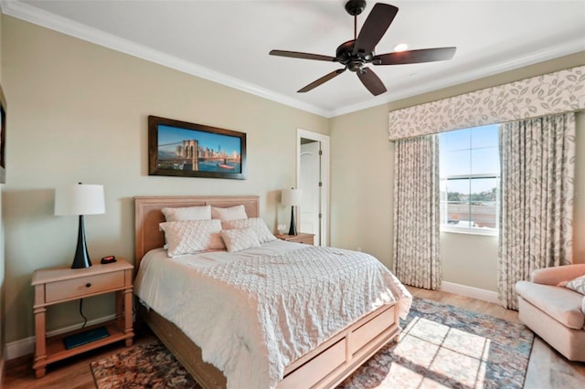 bedroom featuring ceiling fan, baseboards, crown molding, and wood finished floors