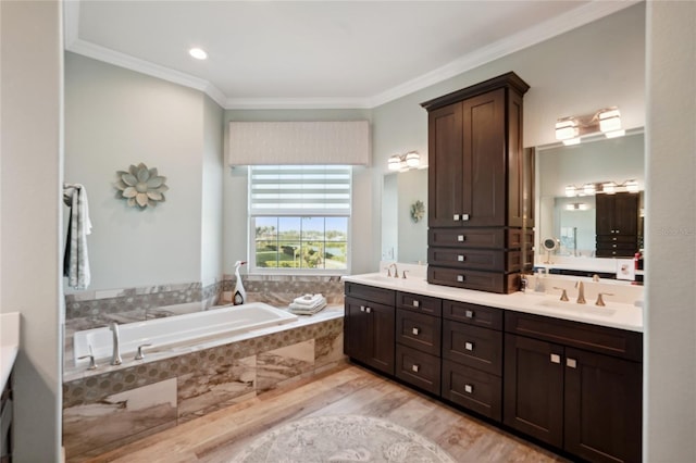 bathroom with crown molding, double vanity, a sink, and a bath