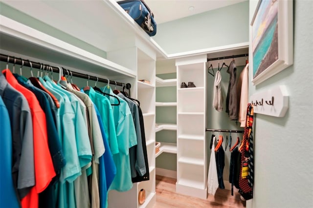 walk in closet with light hardwood / wood-style floors