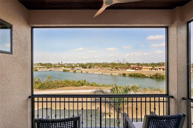 balcony with a ceiling fan and a water view