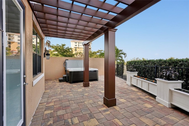 view of patio / terrace with fence, a hot tub, and a pergola