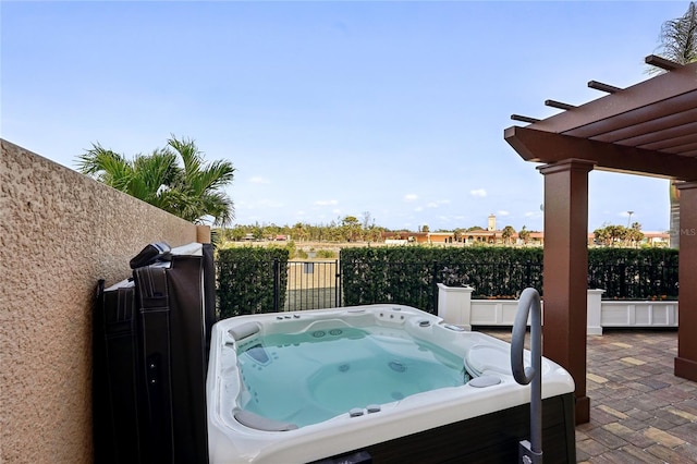 view of patio with a hot tub and a pergola