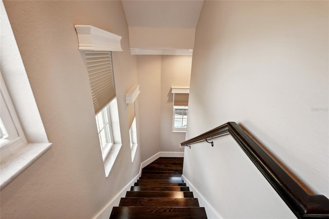 stairway with wood finished floors and baseboards