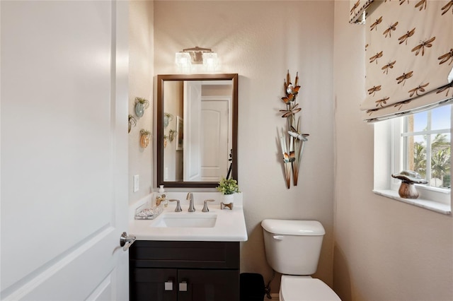 half bathroom with toilet and vanity