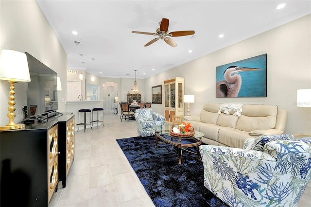 living room with ceiling fan and crown molding