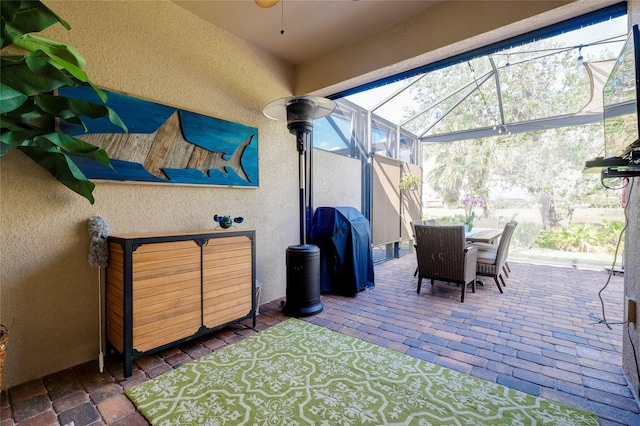 view of patio / terrace with ceiling fan, area for grilling, and a lanai