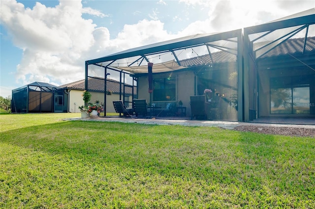 rear view of property featuring a lawn and glass enclosure