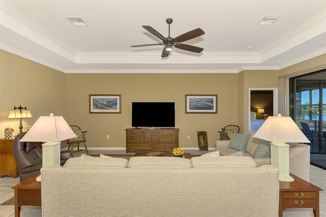 living room featuring a tray ceiling, ceiling fan, and crown molding