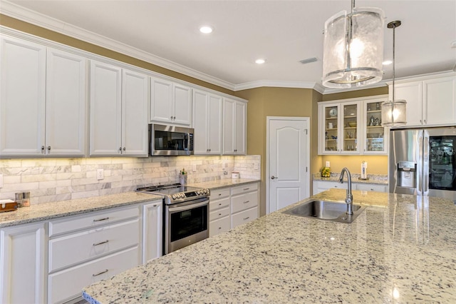 kitchen featuring sink, white cabinets, decorative light fixtures, and appliances with stainless steel finishes