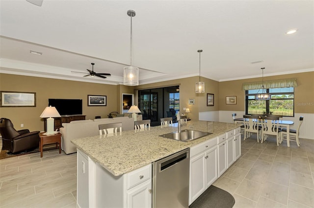 kitchen featuring a center island with sink, sink, hanging light fixtures, stainless steel dishwasher, and white cabinetry