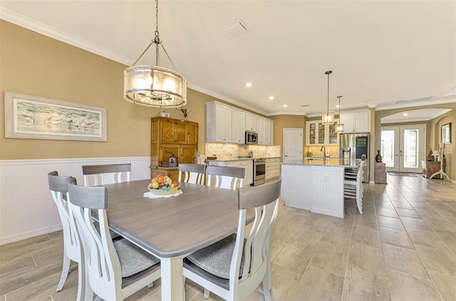 dining room featuring ornamental molding, sink, and french doors