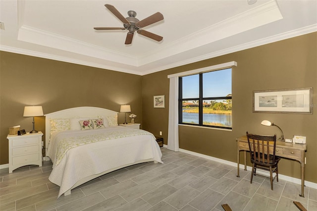 bedroom with a water view, a raised ceiling, ceiling fan, and crown molding