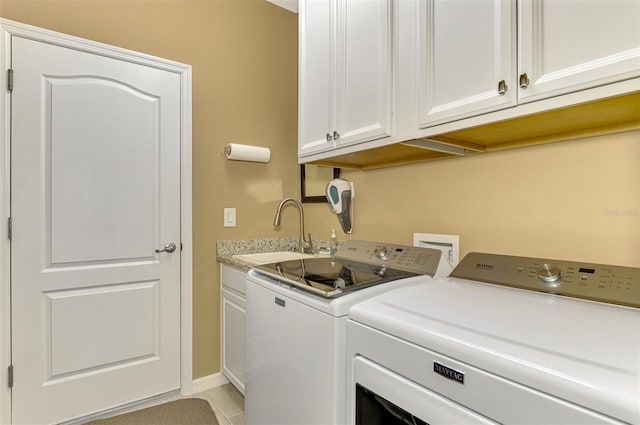 washroom with cabinets, washing machine and dryer, and sink