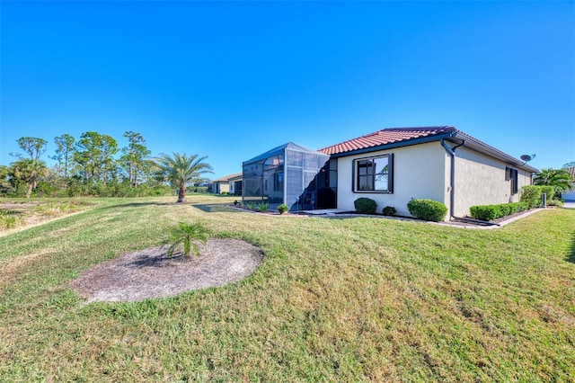 exterior space with a lanai and a lawn