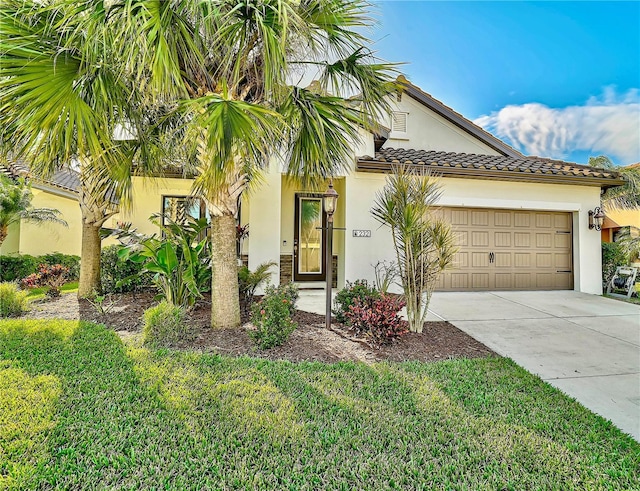 view of front of home with an attached garage, stucco siding, concrete driveway, a front lawn, and a tiled roof