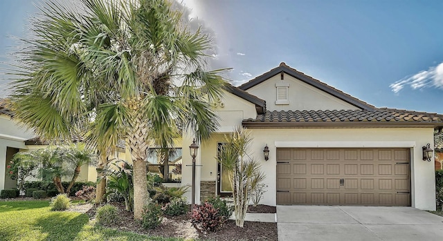 view of front facade featuring a tiled roof, a garage, concrete driveway, and stucco siding