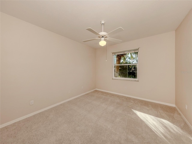 spare room featuring light colored carpet and ceiling fan