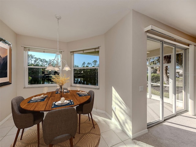 tiled dining room featuring a water view and a wealth of natural light