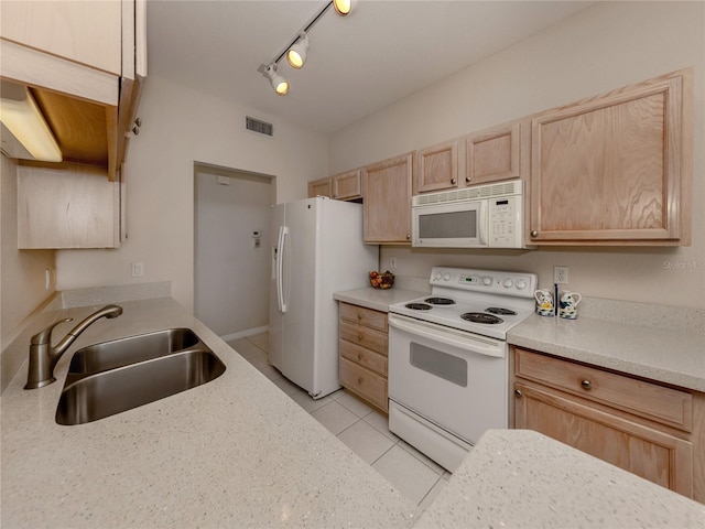 kitchen with white appliances, light brown cabinets, sink, rail lighting, and light tile patterned flooring