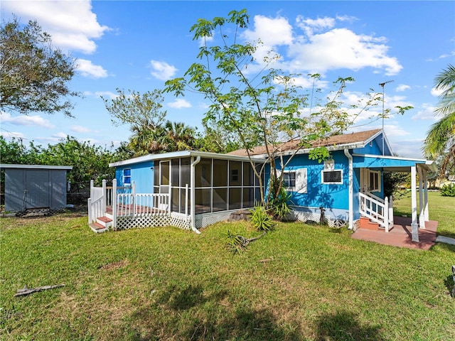 back of house featuring a sunroom, a deck, and a yard