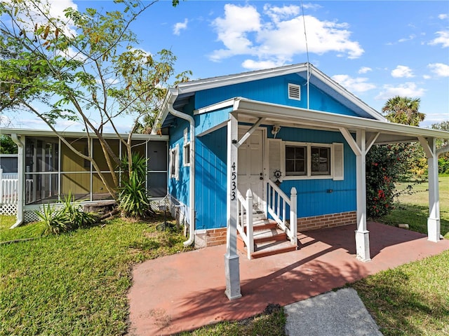 view of front of house with a sunroom and a front lawn