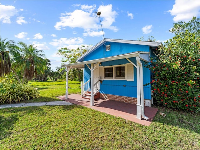 back of property featuring a lawn