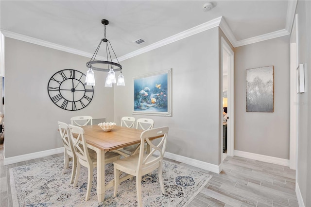 dining room with crown molding, light hardwood / wood-style floors, and a notable chandelier