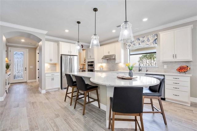 kitchen with white cabinetry, a kitchen island, pendant lighting, and appliances with stainless steel finishes