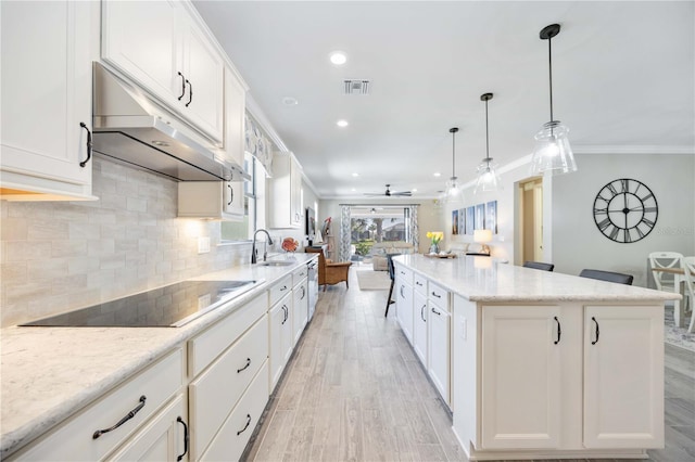 kitchen featuring black electric stovetop, white cabinetry, and crown molding