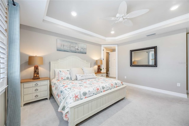 carpeted bedroom with a raised ceiling, ceiling fan, and crown molding