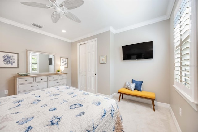 bedroom featuring ornamental molding, a closet, ceiling fan, and light colored carpet