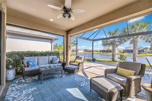 view of patio featuring an outdoor hangout area, a water view, glass enclosure, and ceiling fan