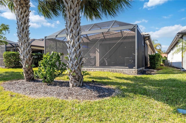 back of house with a yard, central AC, and a lanai