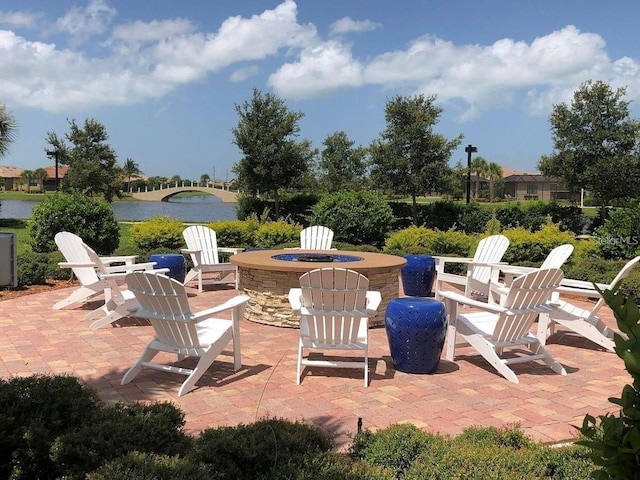 view of patio with a water view and an outdoor fire pit