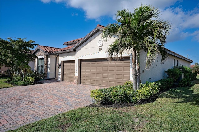 mediterranean / spanish-style house featuring a front yard and a garage