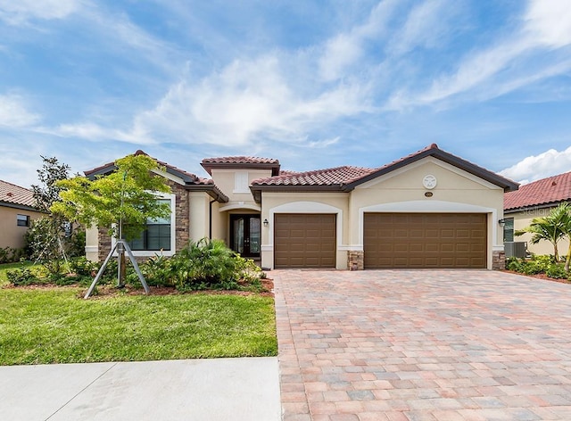 mediterranean / spanish home with french doors, cooling unit, a front yard, and a garage