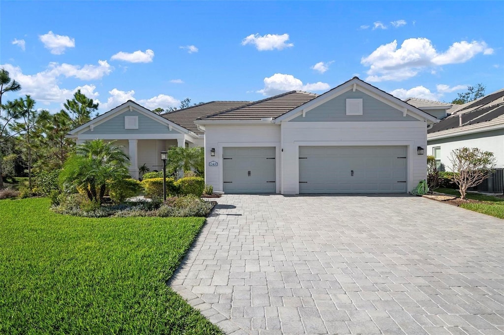 ranch-style home featuring a garage and a front yard